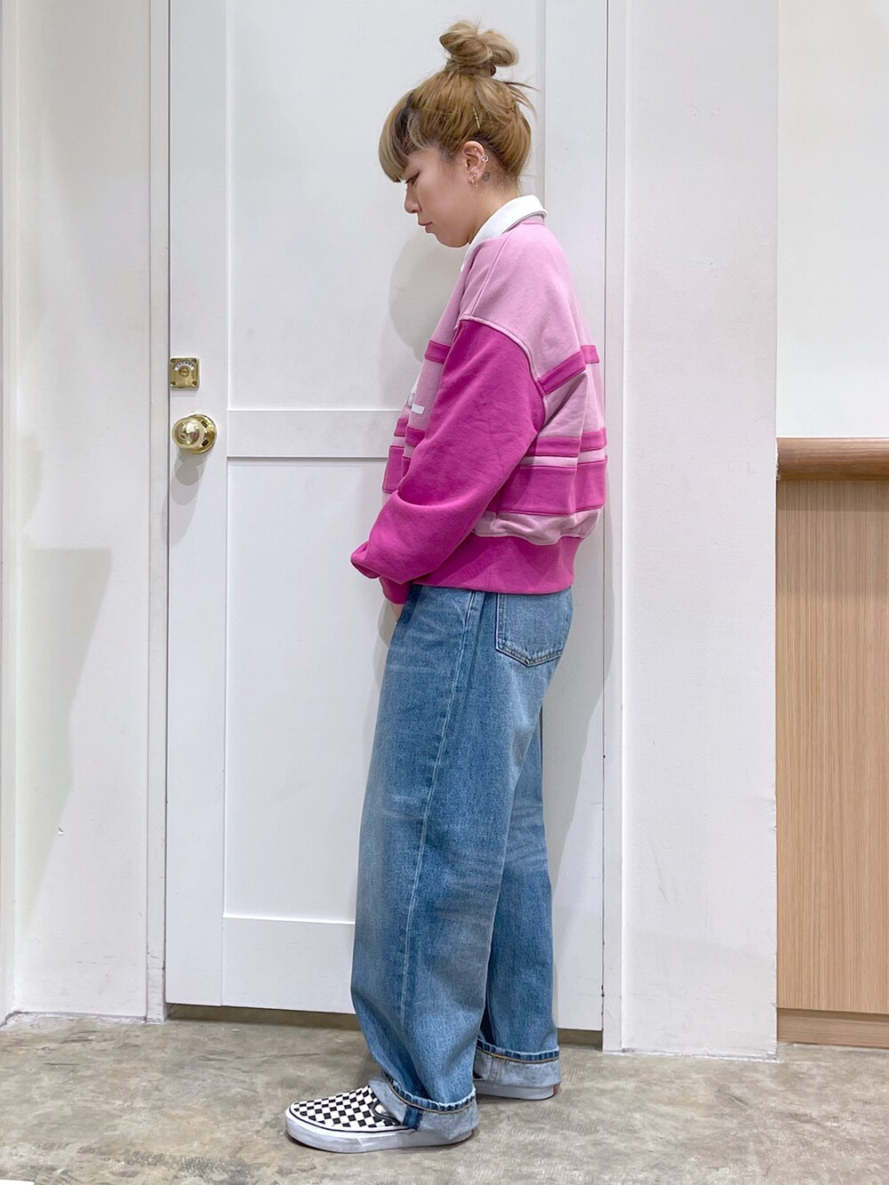 ピンク系のスウェット、ブルー系のデニムパンツ、ホワイト系のトートバッグを着用したレディースの冬コーディネートの4枚目の写真