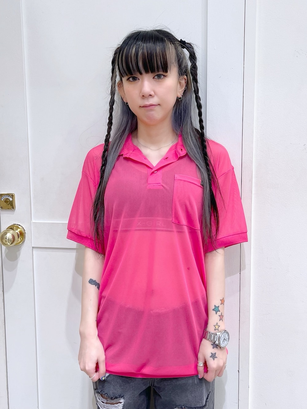 ピンク系のポロシャツ、ブラック系のデニムパンツ、ブラック系のブラ&ショーツを着用したレディースの夏コーディネートの2枚目の写真