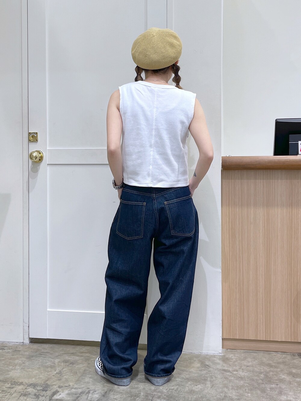 ホワイト系のタンクトップ、ブルー系のデニムパンツ、ベージュ系のハンチング/ベレー帽を着用したレディースの夏コーディネートの4枚目の写真