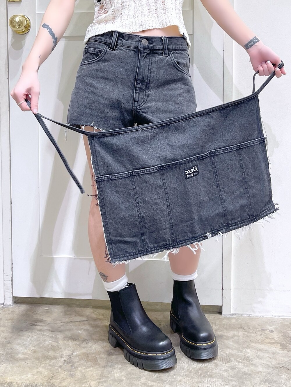 ホワイト系のニット/セーター、ブラック系のタンクトップ、ブルー系のショルダーバッグを着用したレディースの春コーディネートの7枚目の写真