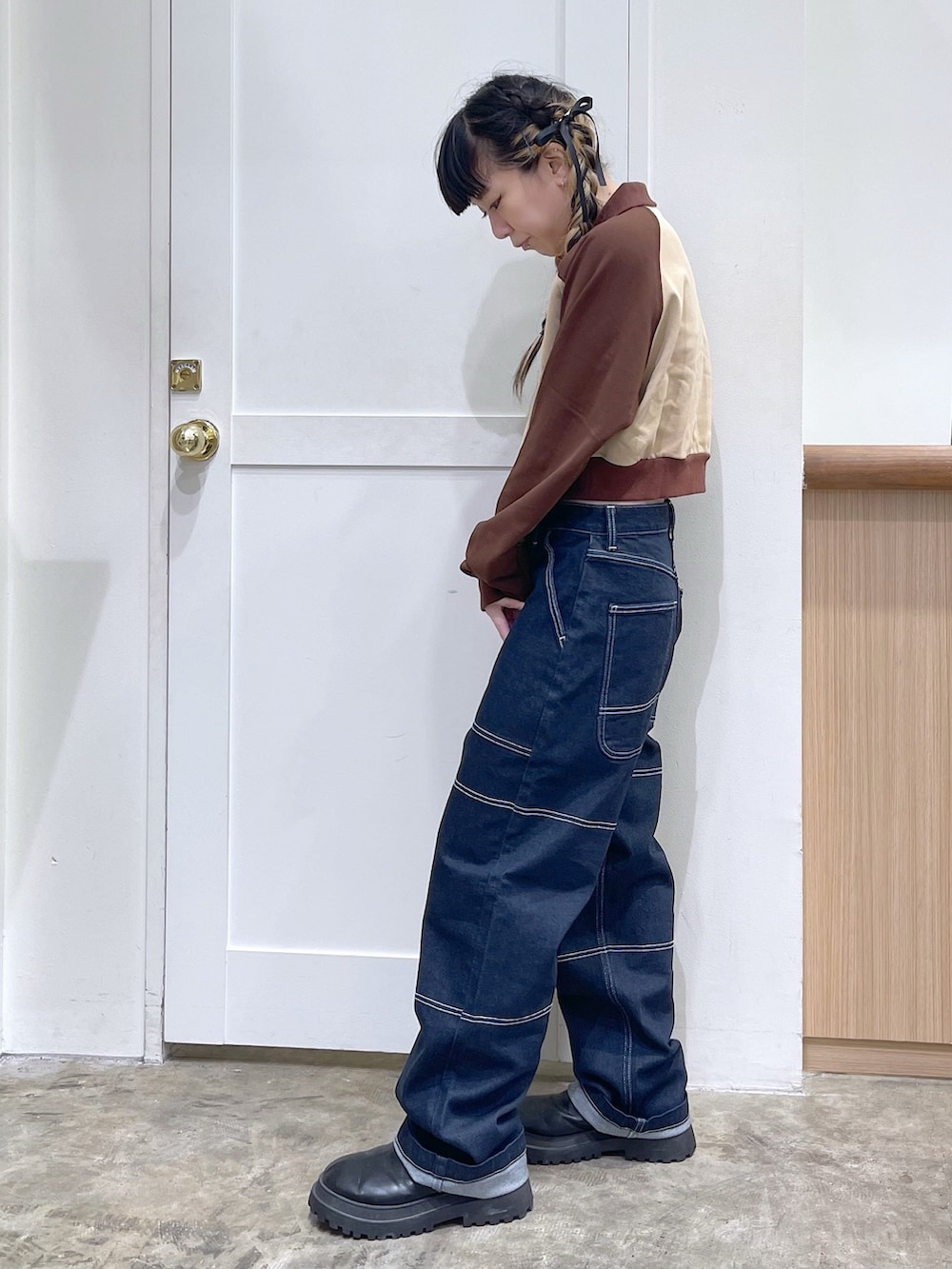 ブラウン系のスウェット、ブルー系のデニムパンツ、イエロー系のハンドバッグを着用したレディースの秋コーディネートの2枚目の写真