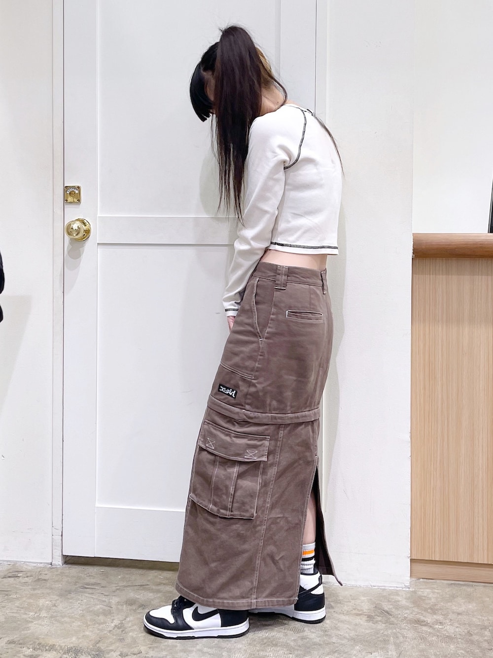 ブラック系のMA-1、ホワイト系のTシャツ/カットソー、グリーン系のスカートを着用したレディースの秋コーディネートの5枚目の写真