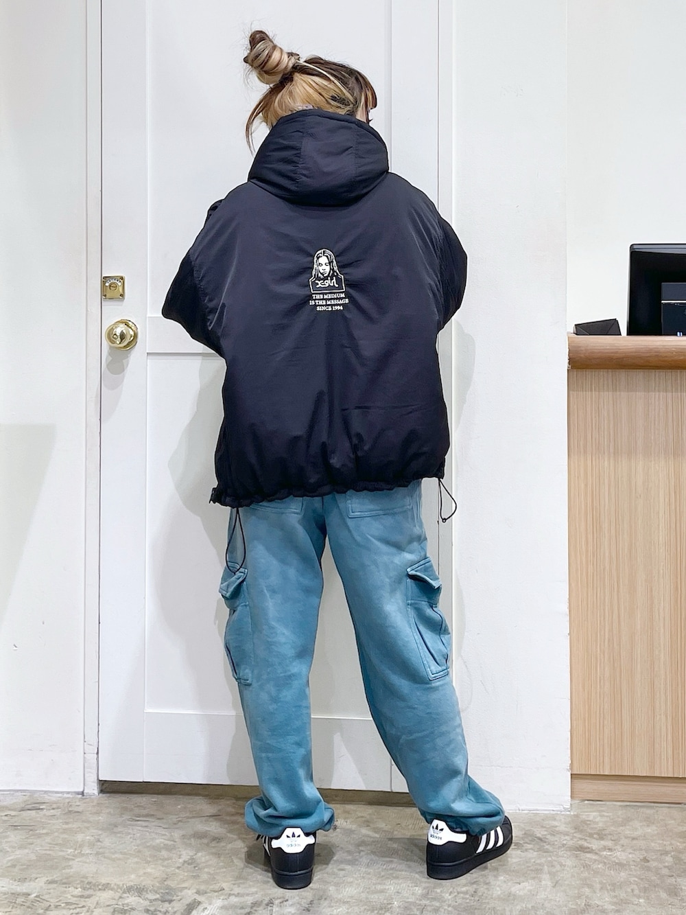 ブラック系のナイロンジャケット、ホワイト系のTシャツ/カットソー、ブルー系のスウェットパンツを着用したレディースの秋コーディネートの3枚目の写真