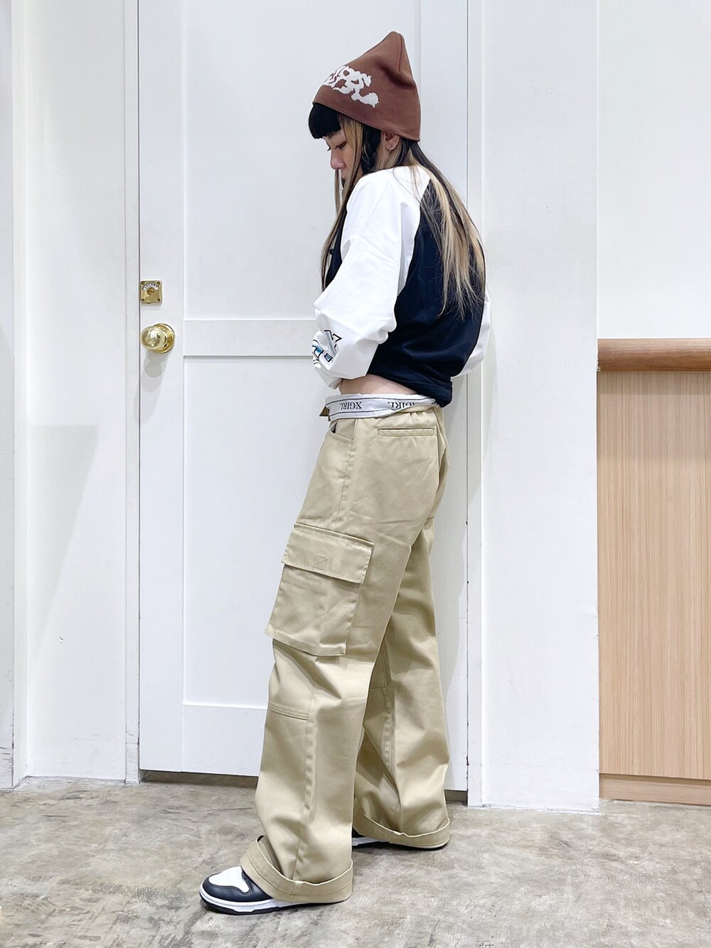 ブラック系のTシャツ/カットソー、ベージュ系のチノパンツ、ブラウン系のニットキャップ/ビーニーを着用したレディースの夏コーディネートの3枚目の写真