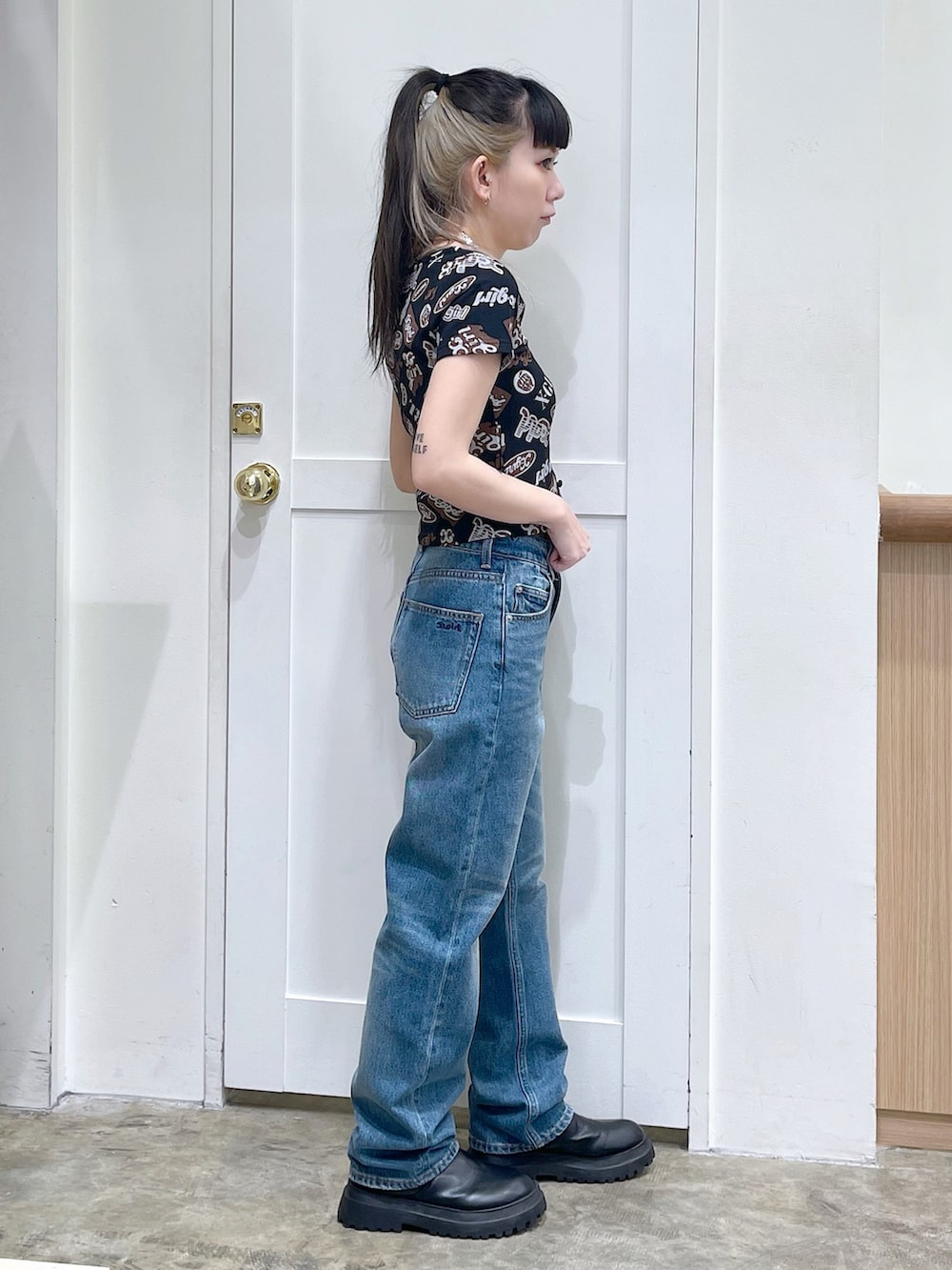 ブラック系のTシャツ/カットソー、ブルー系のデニムパンツ、シルバー系のチョーカーを着用したレディースの春コーディネートの3枚目の写真