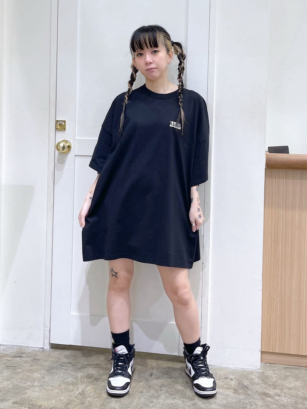 ブラック系のワンピース、ピンク系のショルダーバッグ、ベージュ系の財布を着用したレディースの春コーディネートの3枚目の写真