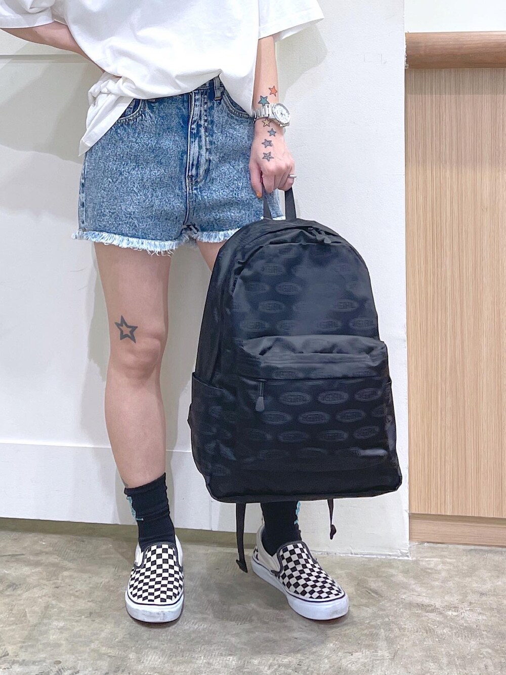 ホワイト系のTシャツ/カットソー、ブルー系のデニムパンツ、ブラック系のバックパック/リュックを着用したレディースの夏コーディネートの2枚目の写真