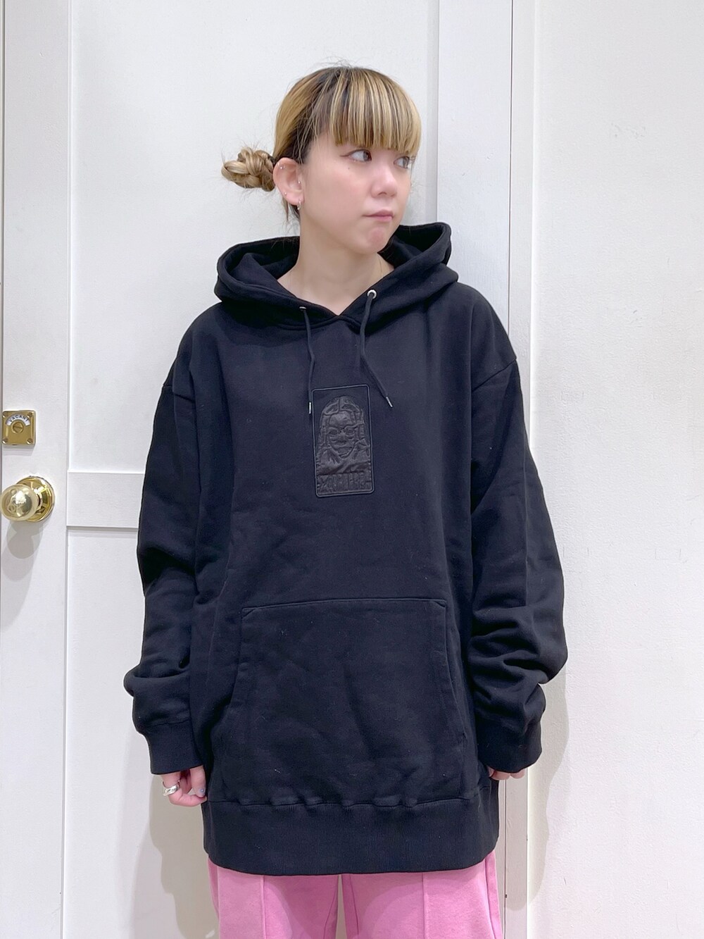 ブラック系のカーディガン/ボレロ、ブラック系のパーカー、ピンク系のスウェットパンツを着用したレディースの冬コーディネートの5枚目の写真