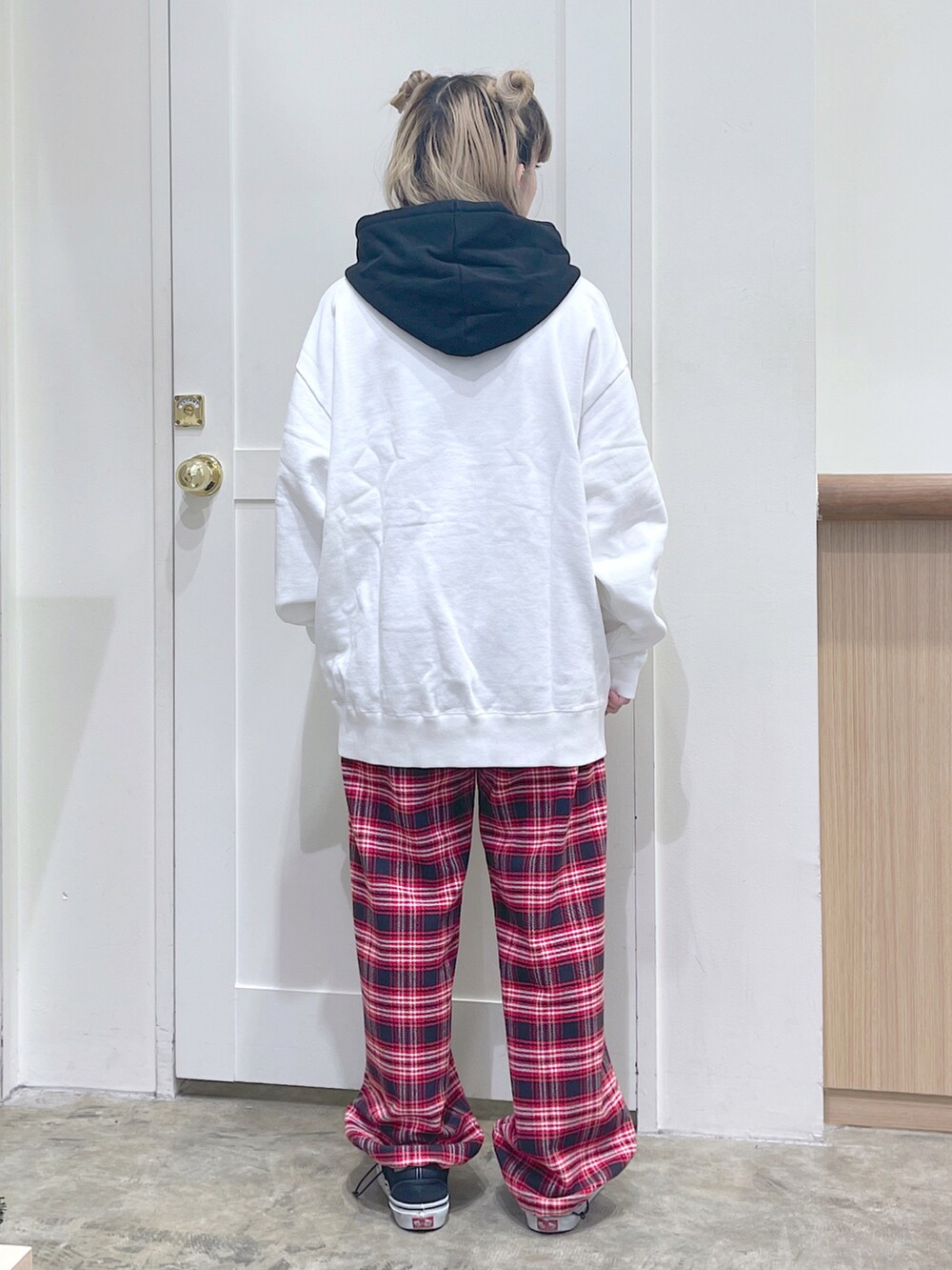 ブラック系のベスト、ホワイト系のパーカー、レッド系のその他パンツを着用したレディースの秋コーディネートの5枚目の写真