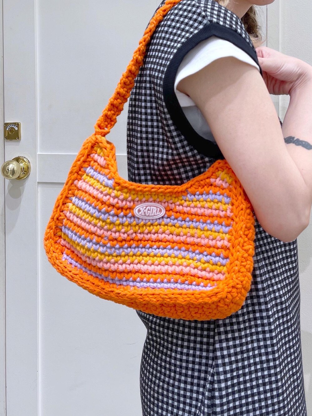 ブラック系のワンピース、ブラック系のその他パンツ、オレンジ系のハンドバッグを着用したレディースの夏コーディネートの4枚目の写真