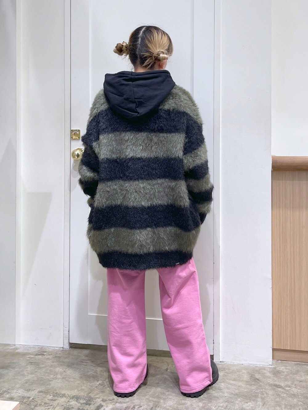 ブラック系のカーディガン/ボレロ、ブラック系のパーカー、ピンク系のスウェットパンツを着用したレディースの冬コーディネートの4枚目の写真