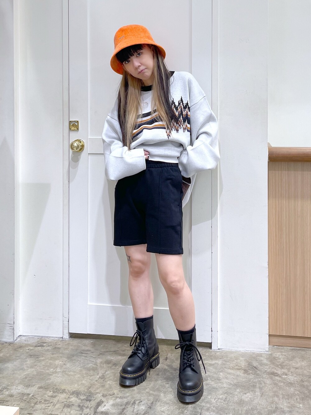 ホワイト系のニット/セーター、ブラック系のスウェットパンツ、ブラック系のブーツを着用したレディースの秋コーディネートの5枚目の写真