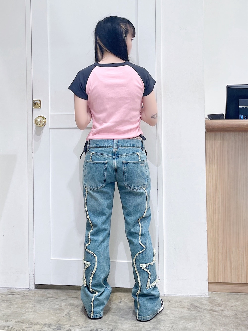 ピンク系のTシャツ/カットソー、ブルー系のデニムパンツ、ブラック系のハンドバッグを着用したレディースの夏コーディネートの4枚目の写真