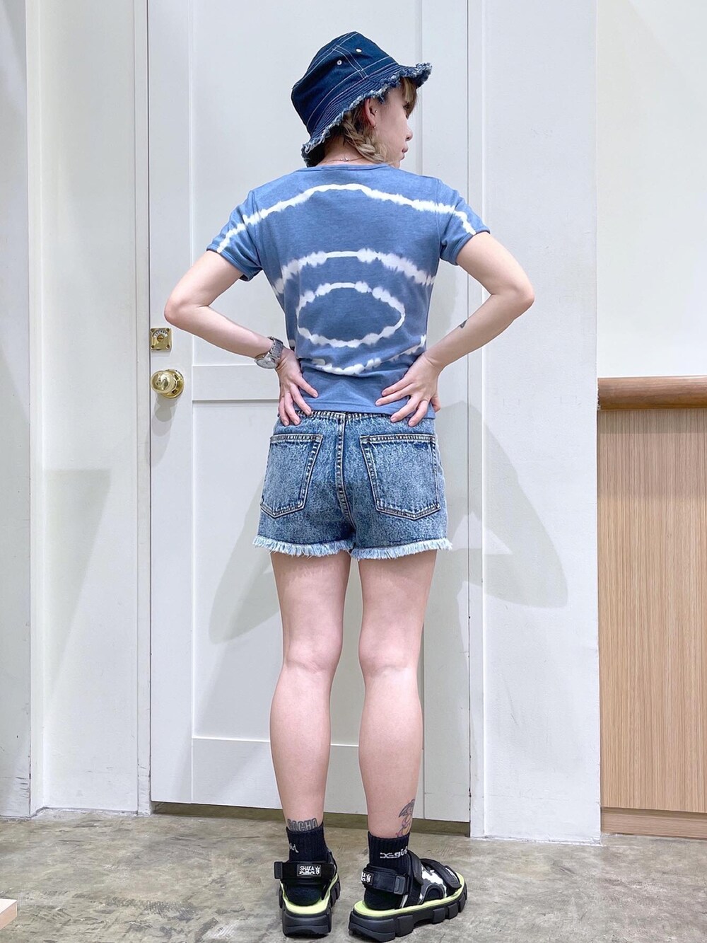 ブルー系のTシャツ/カットソー、ブルー系のデニムパンツ、ブラック系のサンダルを着用したレディースの夏コーディネートの3枚目の写真