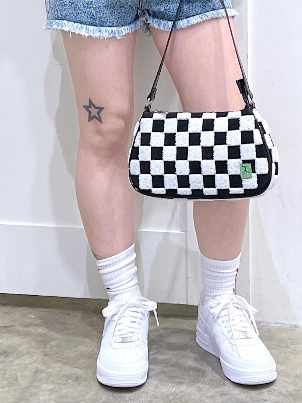 ブラック系のTシャツ/カットソー、ブルー系のデニムパンツ、ホワイト系のハンドバッグを着用したレディースの夏コーディネートの4枚目の写真