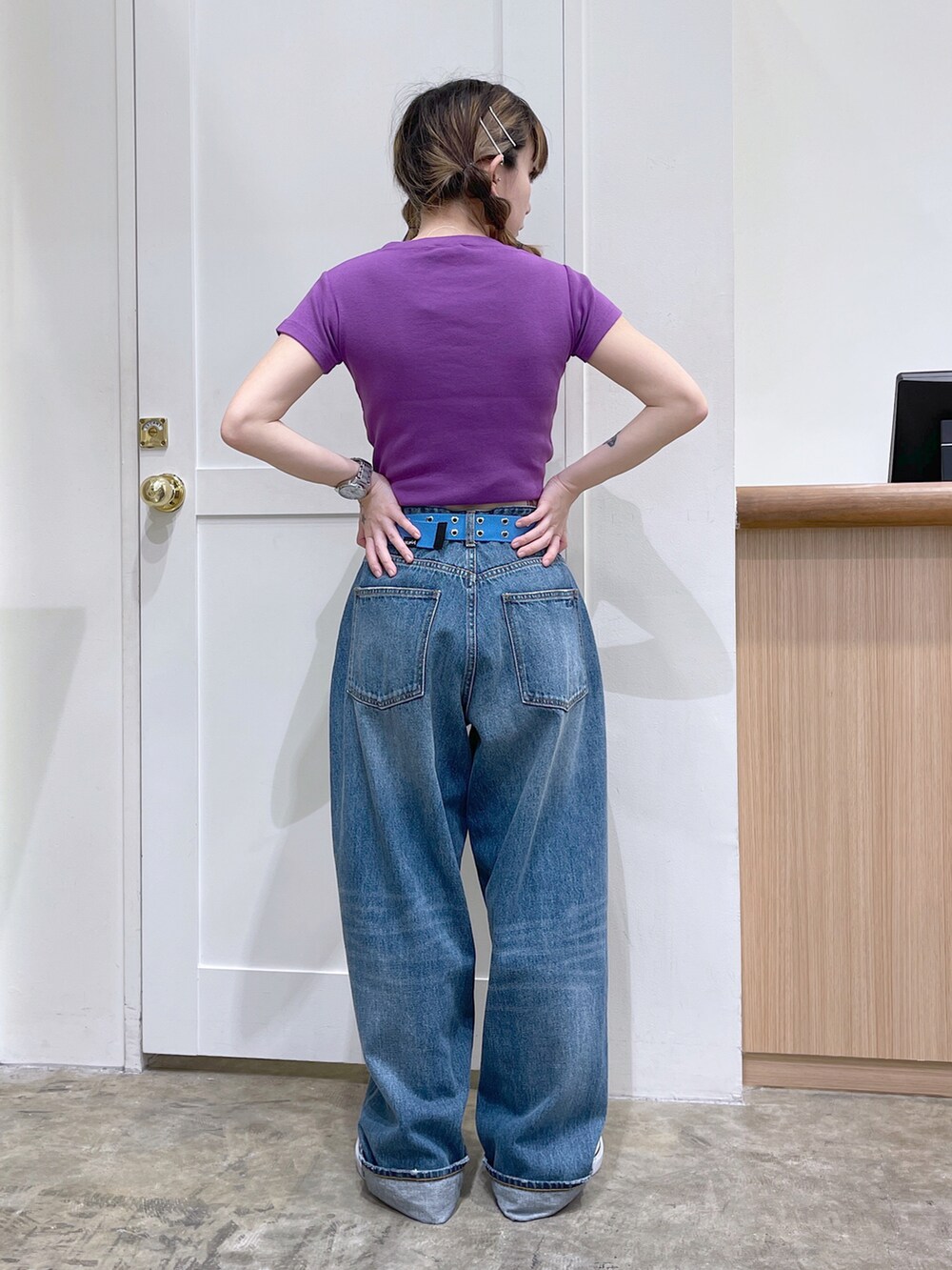 パープル系のTシャツ/カットソー、ブルー系のデニムパンツ、ブルー系のベルトを着用したレディースの夏コーディネートの3枚目の写真