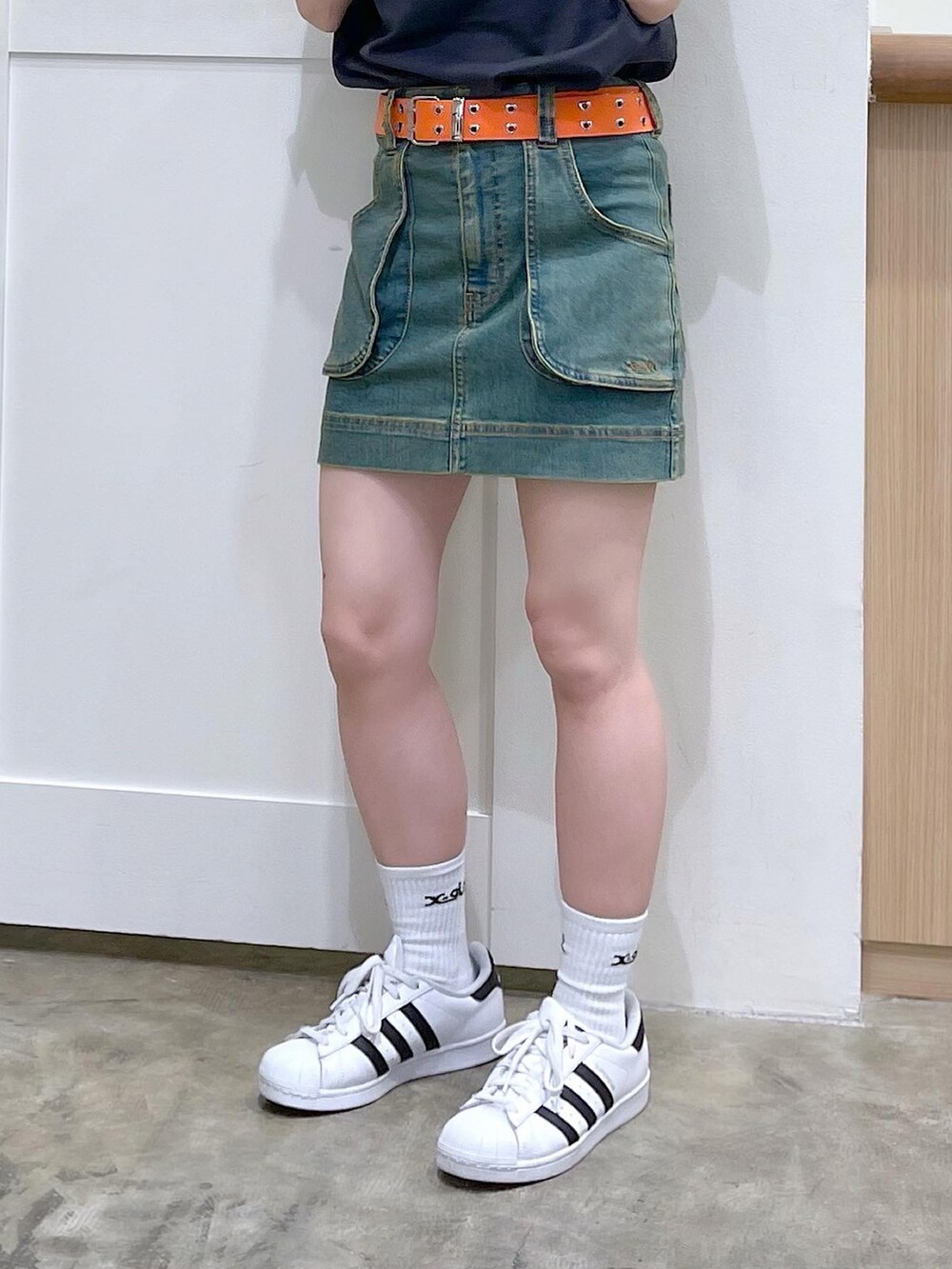 グレー系のTシャツ/カットソー、ブルー系のスカート、オレンジ系のベルトを着用したレディースの夏コーディネートの4枚目の写真