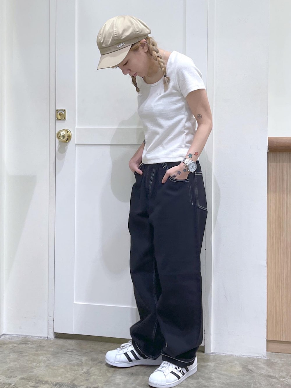 ホワイト系のTシャツ/カットソー、ブラック系のデニムパンツ、ベージュ系のキャスケットを着用したレディースの夏コーディネートの3枚目の写真