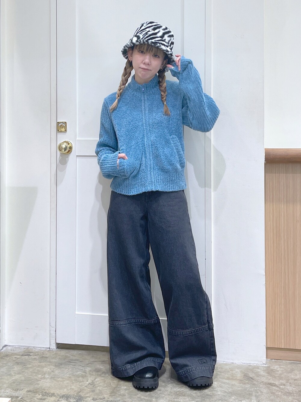 ブルー系のニット/セーター、ブラック系のデニムパンツ、ホワイト系のハットを着用したレディースの秋コーディネートの2枚目の写真