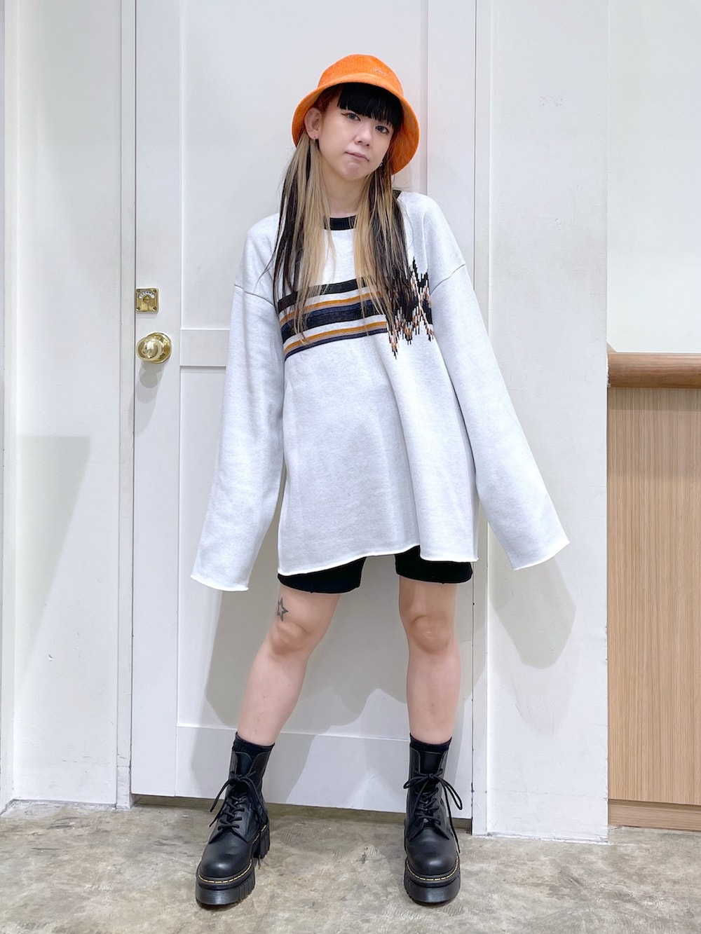 ホワイト系のニット/セーター、ブラック系のスウェットパンツ、ブラック系のブーツを着用したレディースの秋コーディネートの2枚目の写真