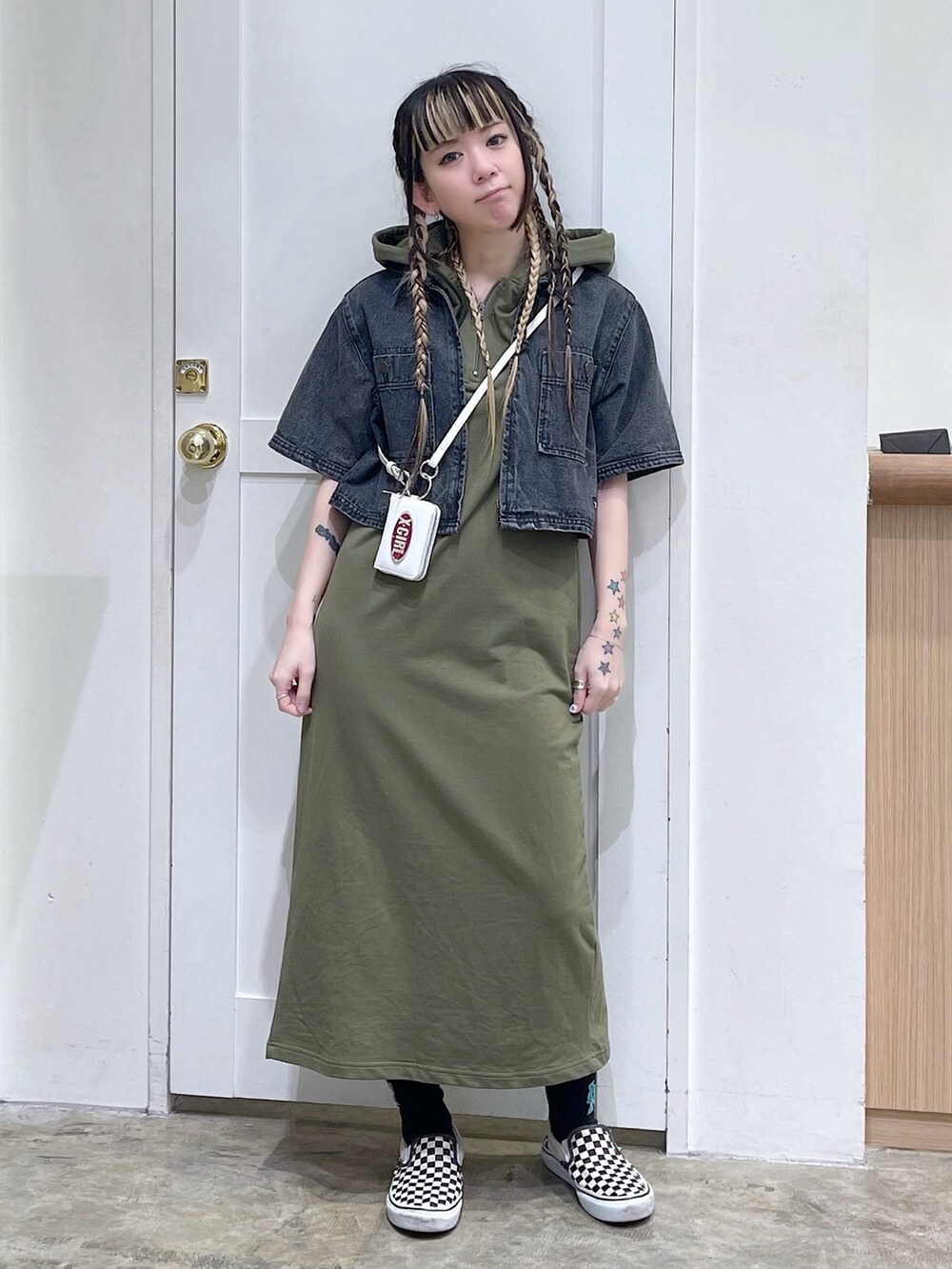 ブラック系のシャツ/ブラウス、グリーン系のワンピース、ホワイト系のコインケースを着用したレディースの春コーディネートの2枚目の写真