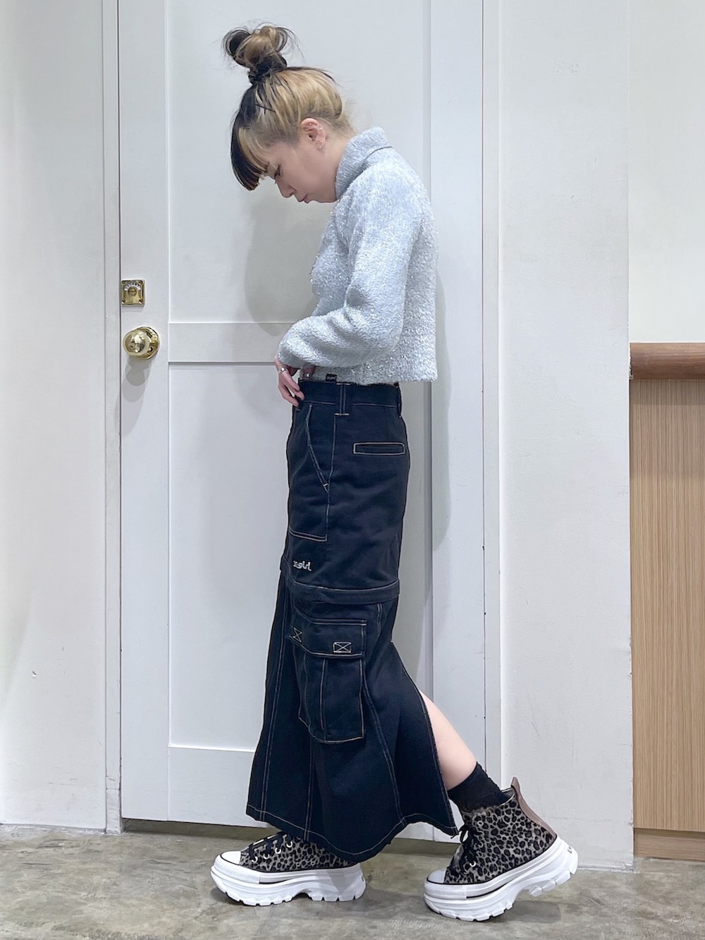 グレー系のニット/セーター、ブラック系のショルダーバッグ、ブラック系のスカートを着用したレディースの秋コーディネートの3枚目の写真