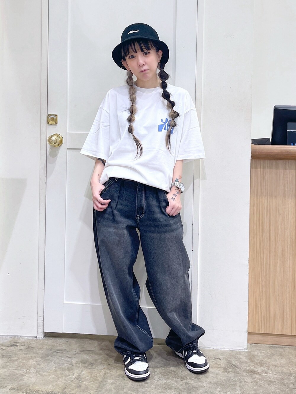 ホワイト系のTシャツ/カットソー、ブラック系のデニムパンツ、ブラック系のハットを着用したレディースの夏コーディネートの2枚目の写真