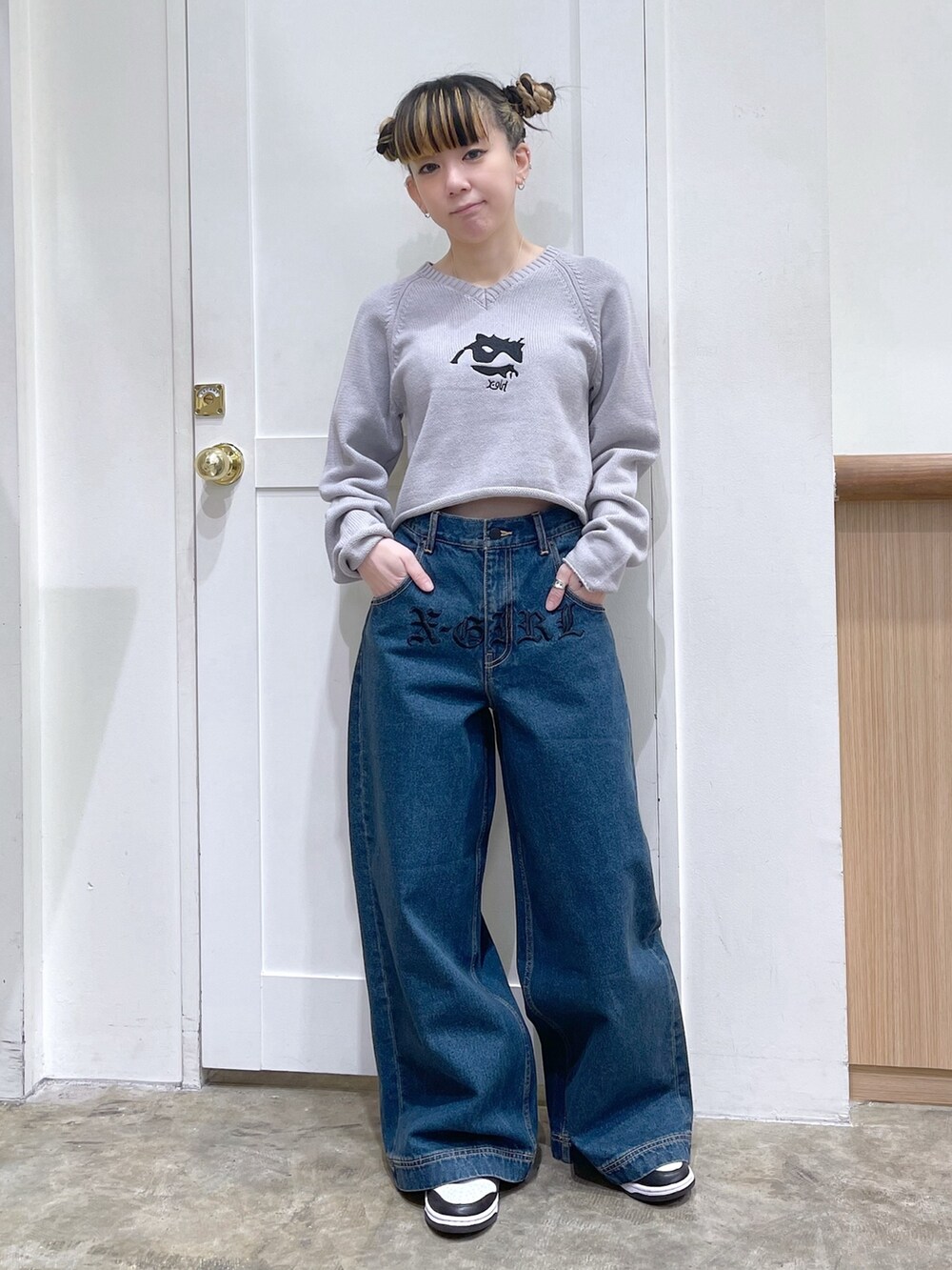 レッド系のスウェット、ブルー系のボストンバッグ、ブルー系のデニムパンツを着用したレディースの冬コーディネートの5枚目の写真