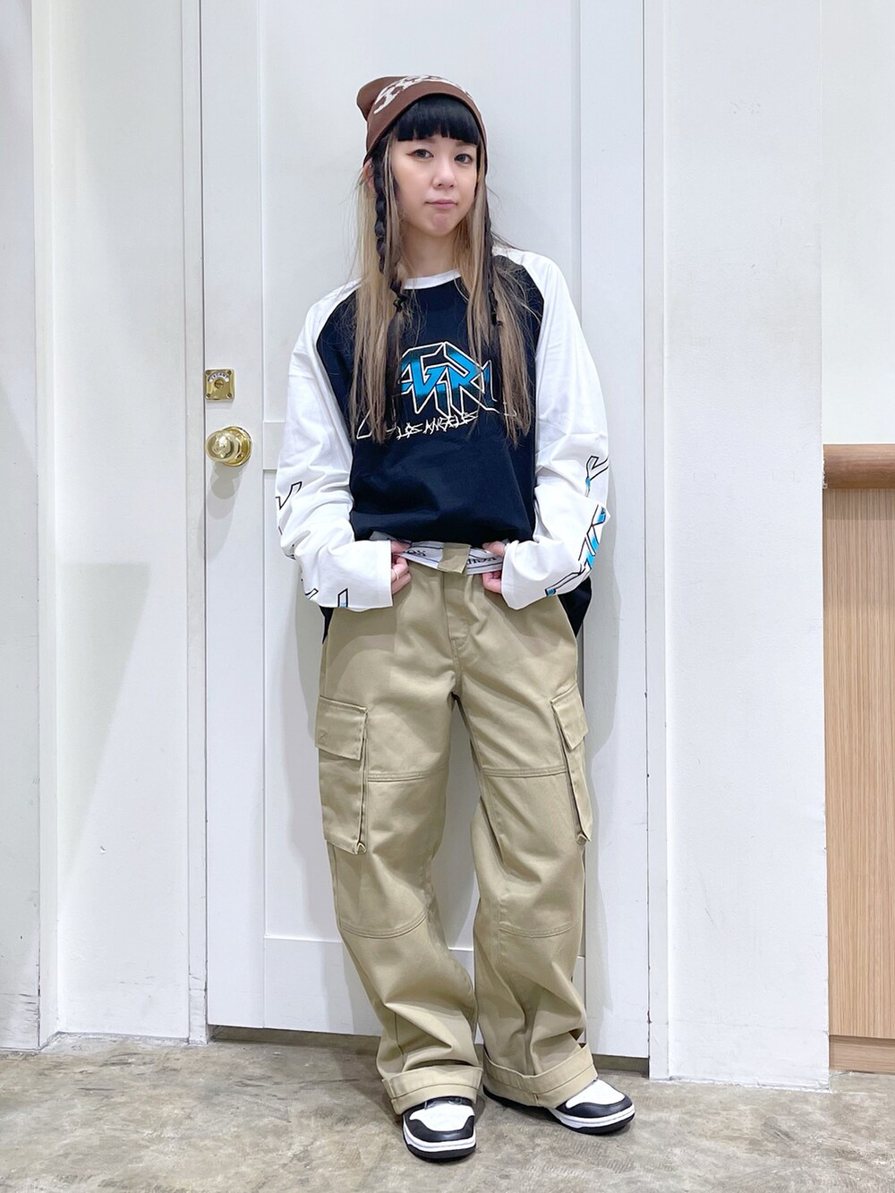 ブラック系のTシャツ/カットソー、ベージュ系のチノパンツ、ブラウン系のニットキャップ/ビーニーを着用したレディースの夏コーディネートの2枚目の写真