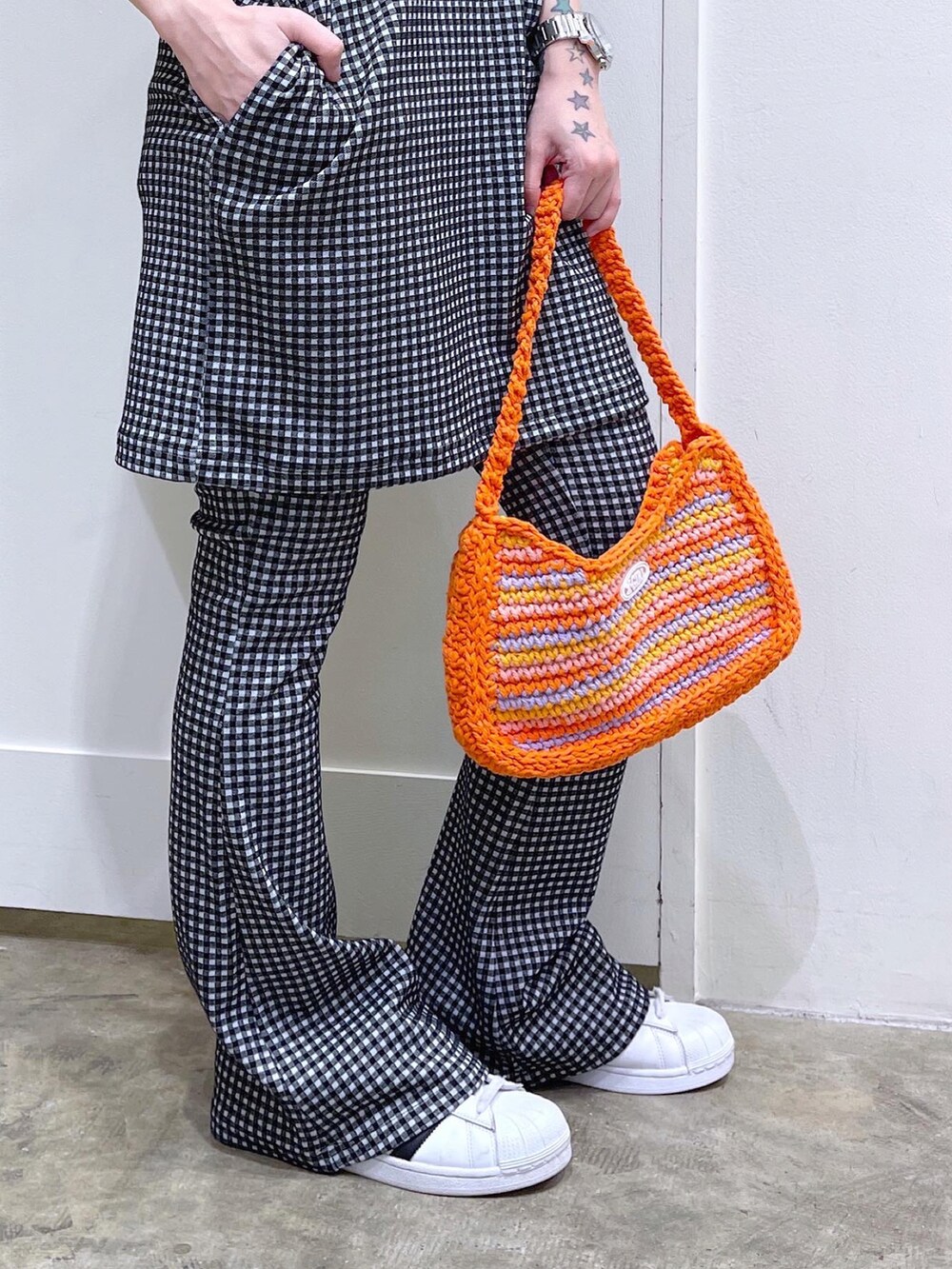 ブラック系のワンピース、ブラック系のその他パンツ、オレンジ系のハンドバッグを着用したレディースの夏コーディネートの5枚目の写真