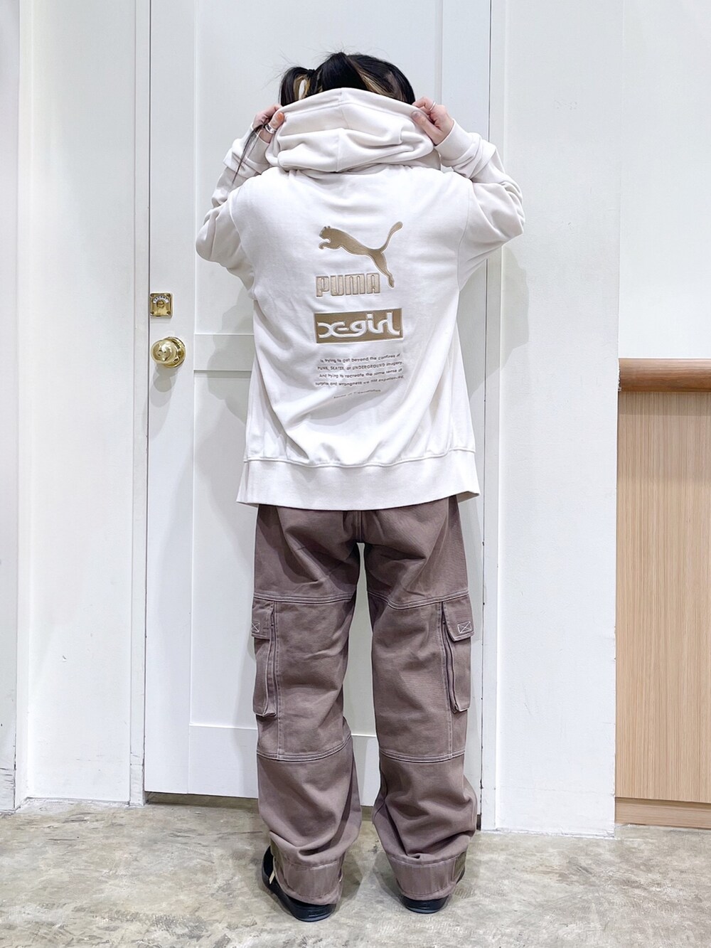 ベージュ系のパーカー、ホワイト系のニット/セーター、グリーン系のカーゴパンツを着用したレディースの秋コーディネートの3枚目の写真