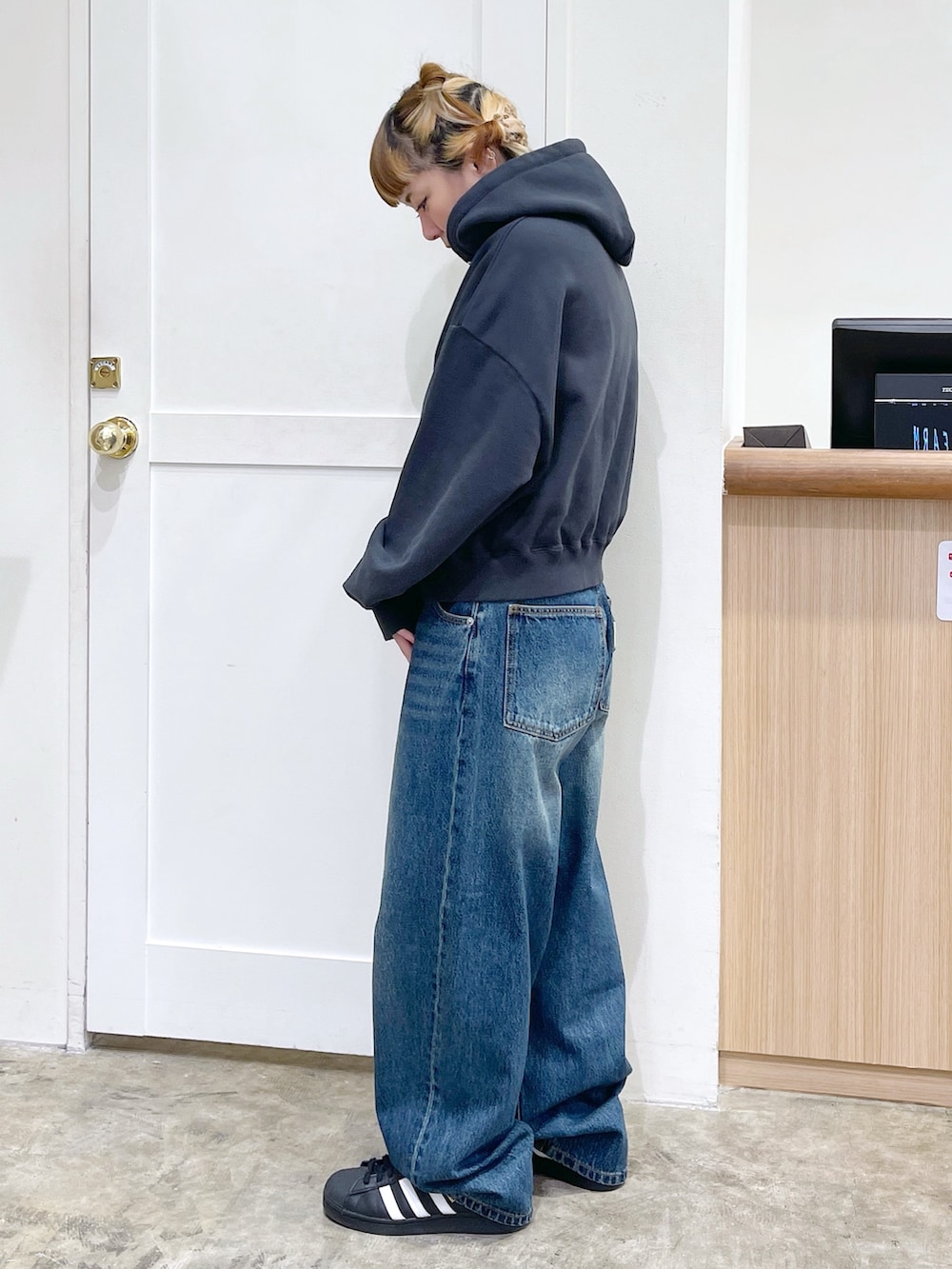 ブラック系のパーカー、ホワイト系のTシャツ/カットソー、ブルー系のデニムパンツを着用したレディースの春コーディネートの3枚目の写真