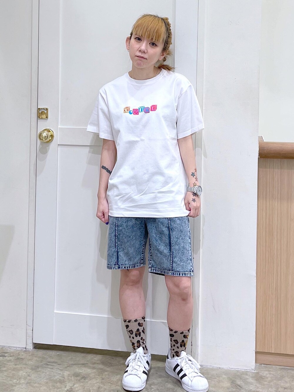ホワイト系のTシャツ/カットソー、ブルー系のデニムパンツ、ベージュ系のソックス/靴下を着用したレディースの夏コーディネートの4枚目の写真