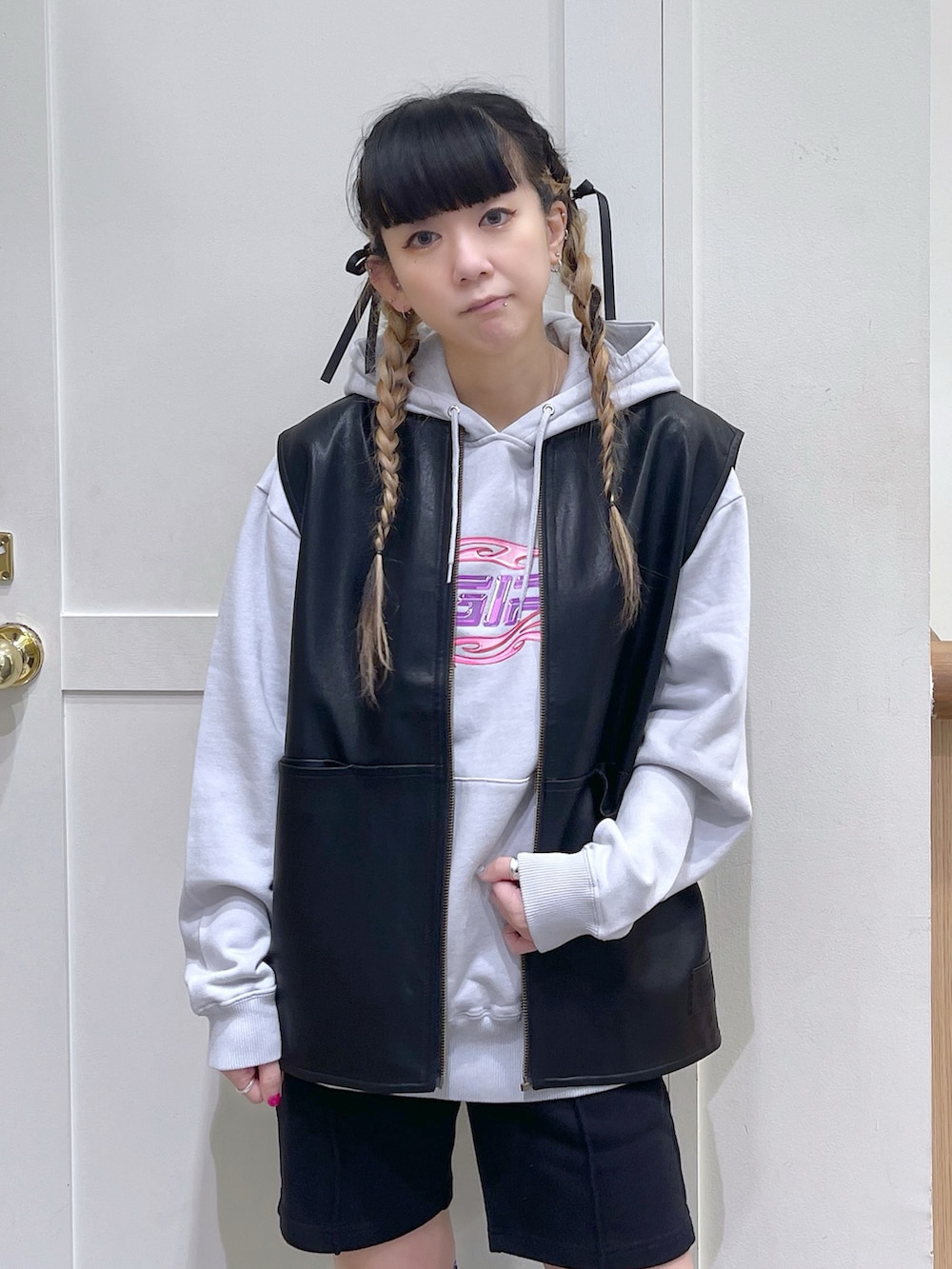 グレー系のパーカー、ブラック系のベスト、ブラック系のスウェットパンツを着用したレディースの秋コーディネートの5枚目の写真