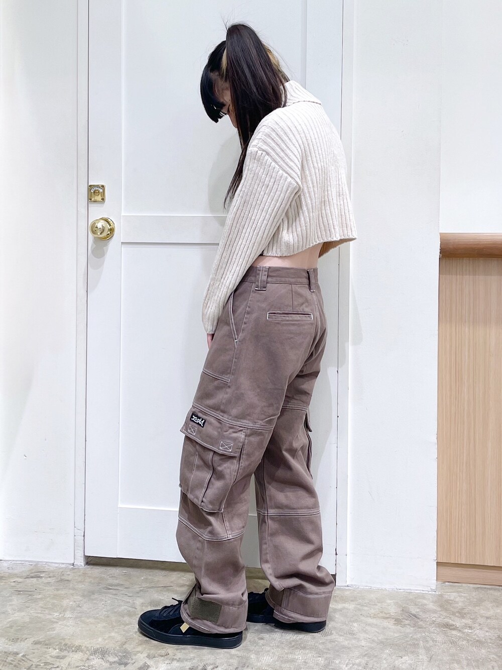 ベージュ系のパーカー、ホワイト系のニット/セーター、グリーン系のカーゴパンツを着用したレディースの秋コーディネートの5枚目の写真