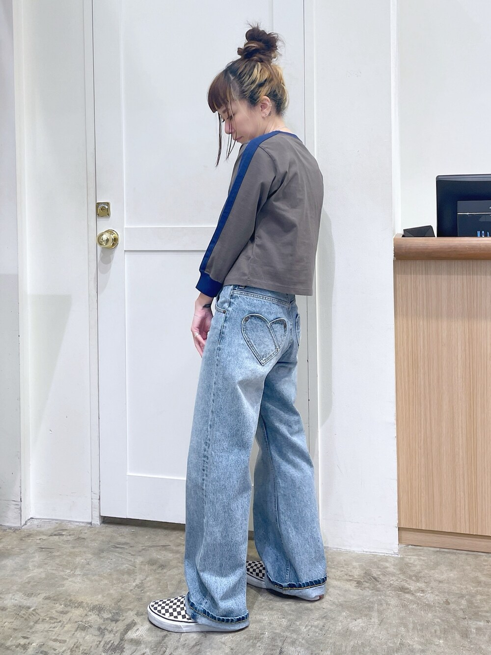 グリーン系のTシャツ/カットソー、ブルー系のデニムパンツ、シルバー系のハンドバッグを着用したレディースの秋コーディネートの3枚目の写真