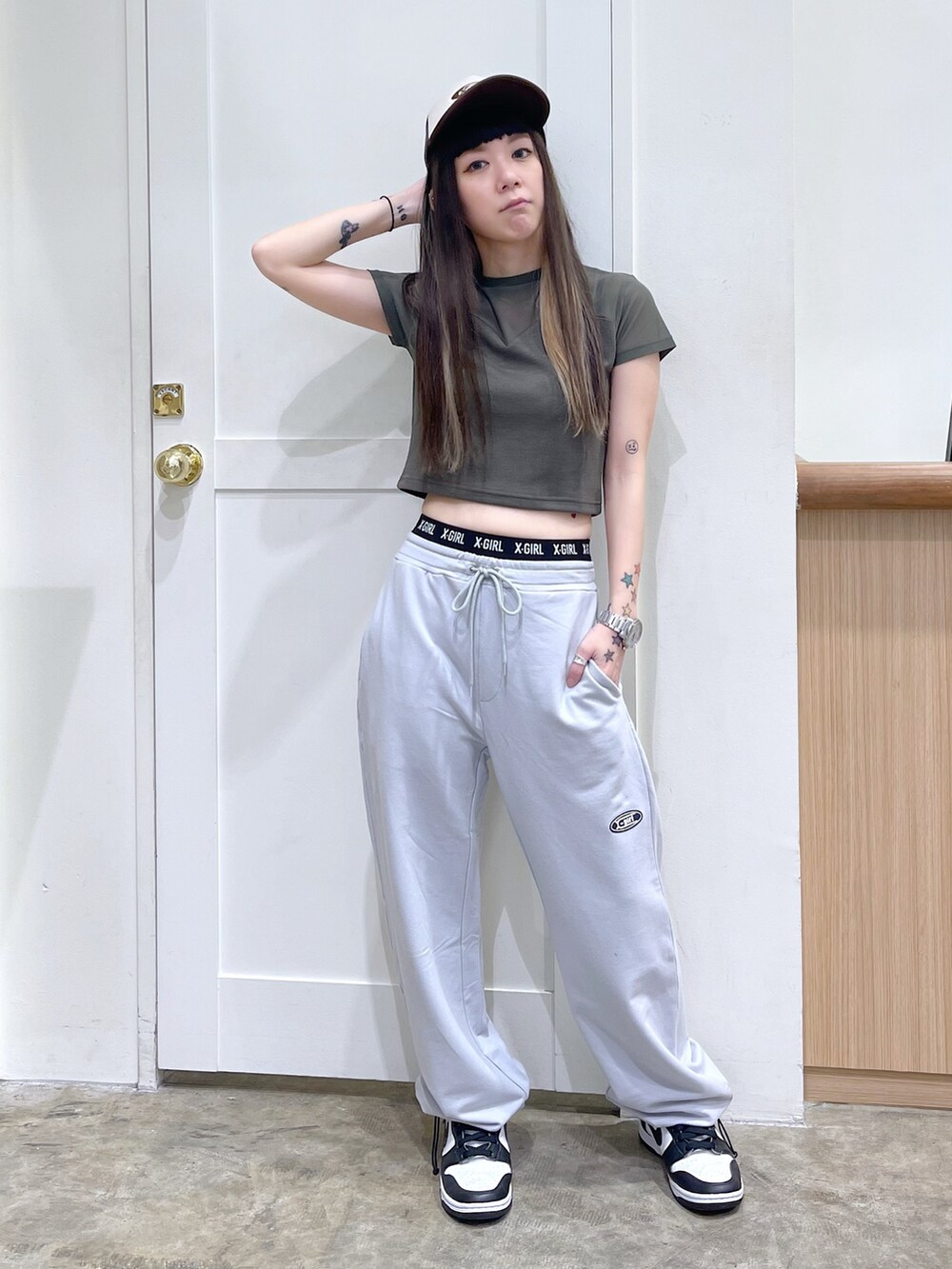 グリーン系のTシャツ/カットソー、グレー系のスウェットパンツ、ブラウン系のキャップを着用したレディースの夏コーディネートの2枚目の写真