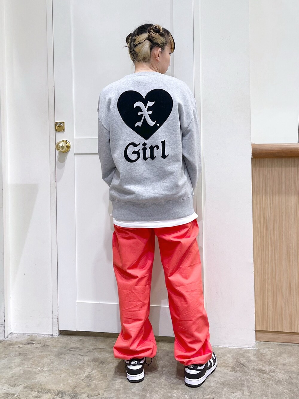 ブラック系のスタジャン、グレー系のスウェット、オレンジ系のその他パンツを着用したレディースの冬コーディネートの7枚目の写真