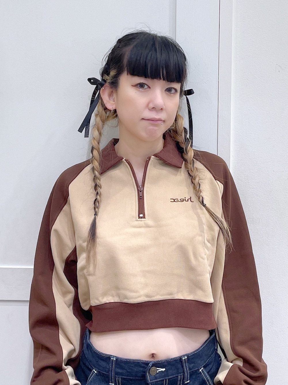 ブラウン系のスウェット、ブルー系のデニムパンツ、イエロー系のハンドバッグを着用したレディースの秋コーディネートの4枚目の写真