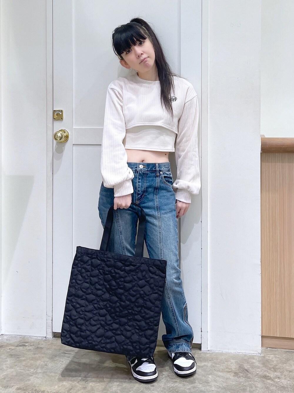 ホワイト系のTシャツ/カットソー、ブルー系のデニムパンツ、ブラック系のトートバッグを着用したレディースの秋コーディネートの2枚目の写真