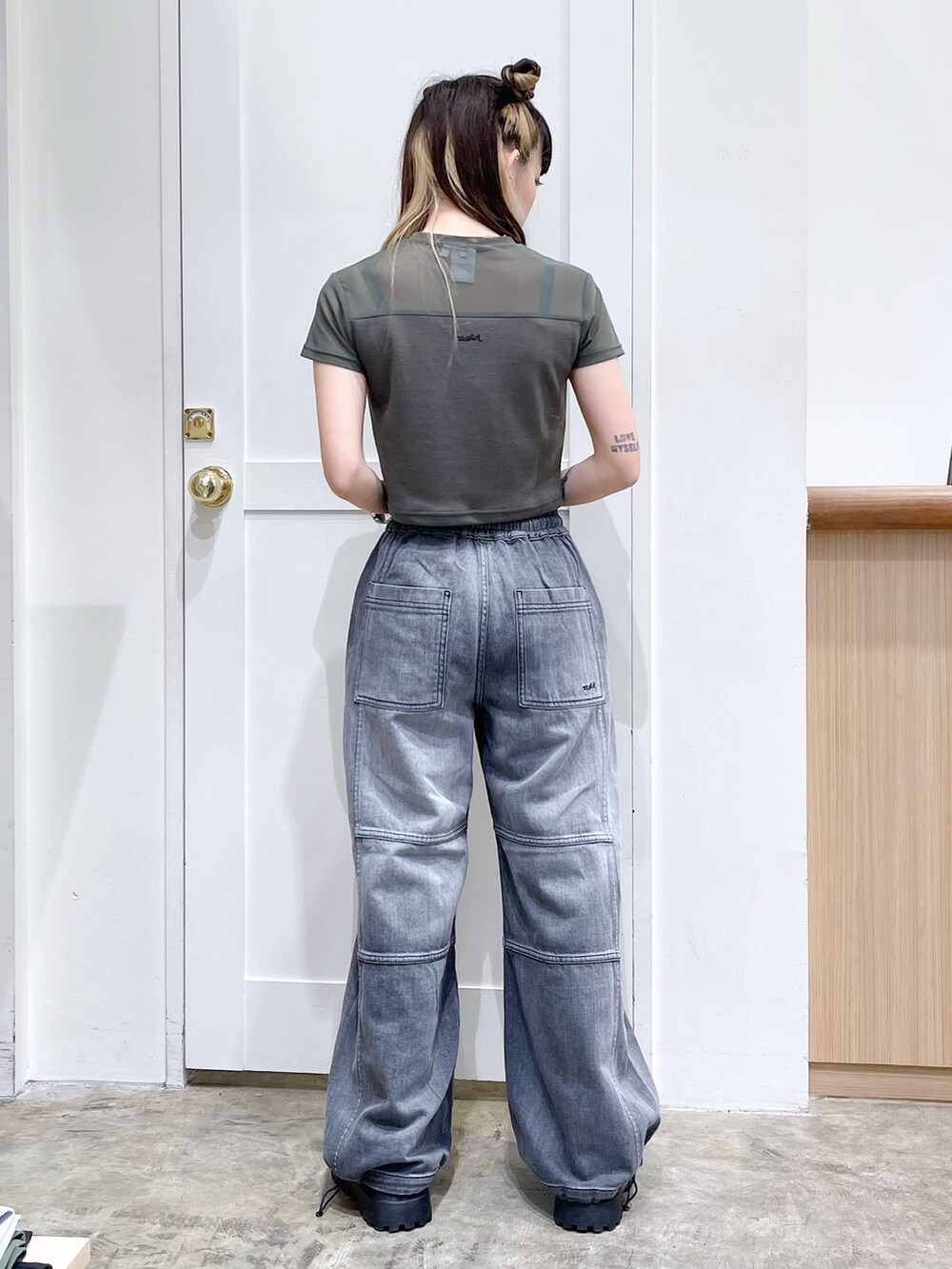 グリーン系のTシャツ/カットソー、ブラック系のデニムパンツ、ブラウン系のバックパック/リュックを着用したレディースの夏コーディネートの4枚目の写真