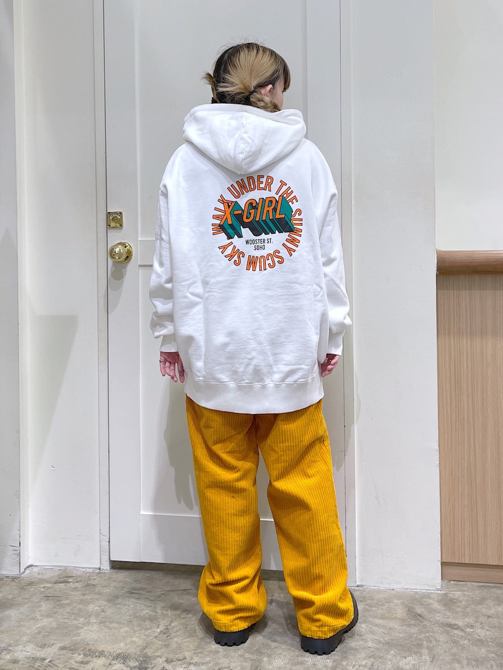 ブラック系のその他アウター、ホワイト系のパーカー、イエロー系のその他パンツを着用したレディースの冬コーディネートの5枚目の写真
