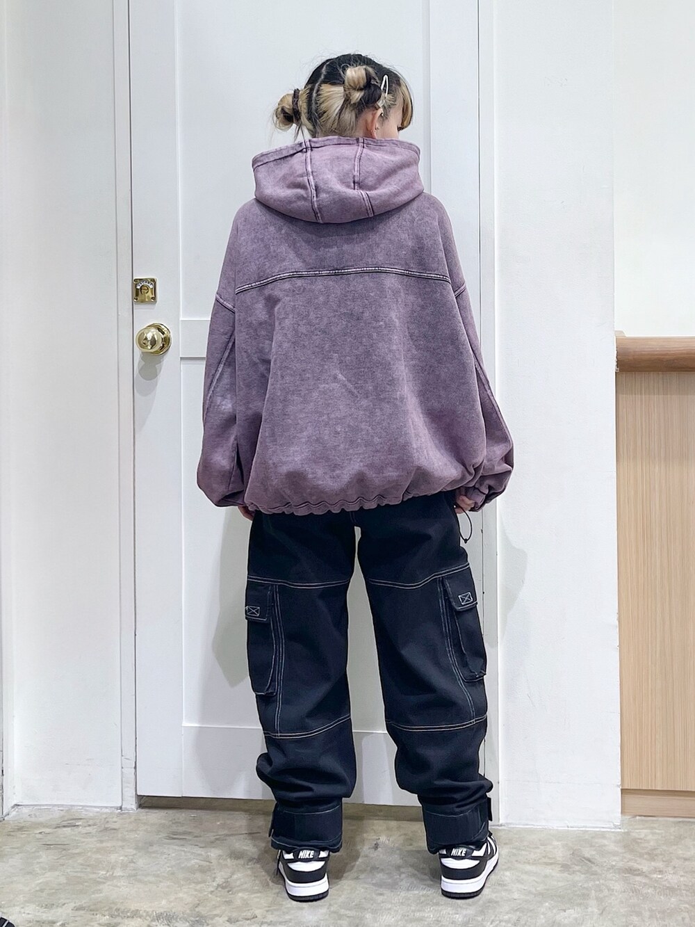 ピンク系のパーカー、グリーン系のショルダーバッグ、ブラック系のカーゴパンツを着用したレディースの冬コーディネートの3枚目の写真