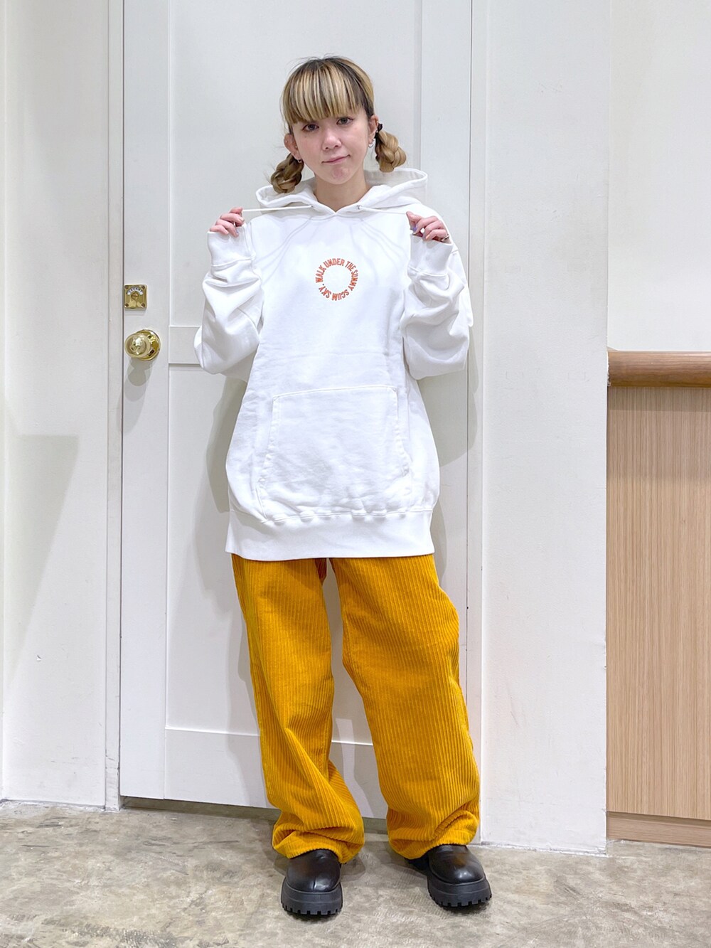 ブラック系のその他アウター、ホワイト系のパーカー、イエロー系のその他パンツを着用したレディースの冬コーディネートの4枚目の写真