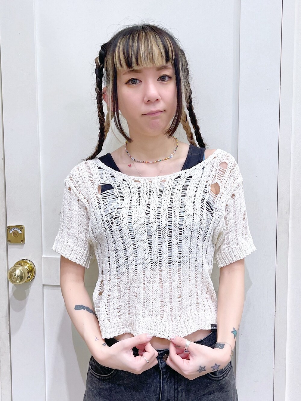 ホワイト系のニット/セーター、ブラック系のタンクトップ、ブルー系のショルダーバッグを着用したレディースの春コーディネートの8枚目の写真