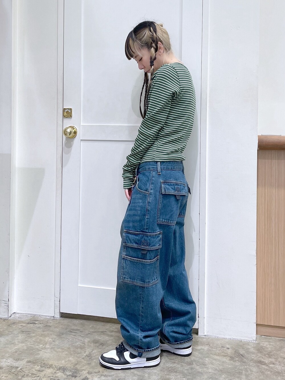 グリーン系のTシャツ/カットソー、ブルー系のデニムパンツ、ブラック系のショルダーバッグを着用したレディースの冬コーディネートの2枚目の写真