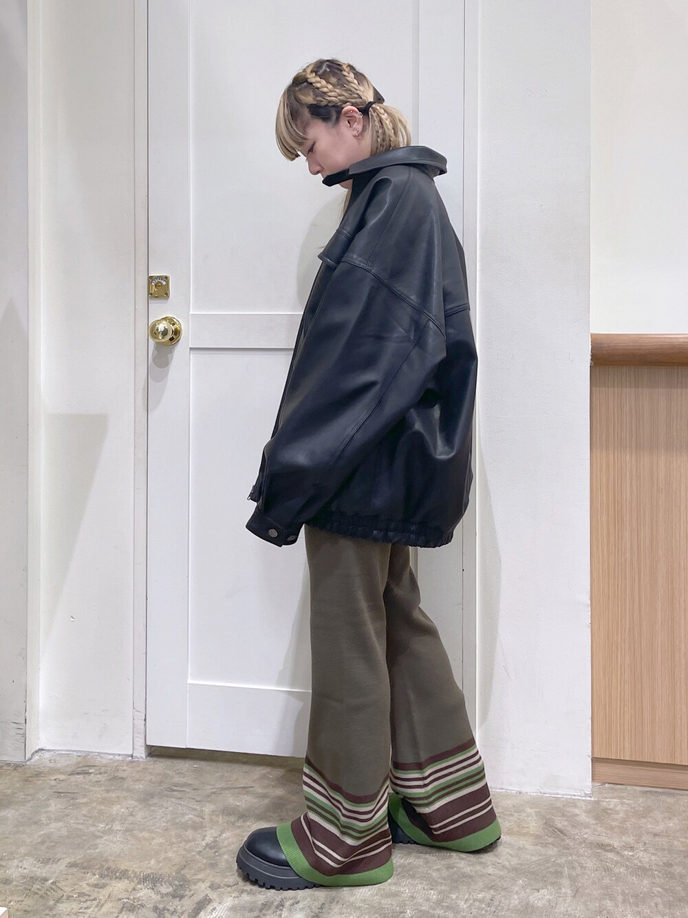 ブラック系のライダースジャケット、グリーン系のカーディガン/ボレロ、グリーン系のその他パンツを着用したレディースの秋コーディネートの2枚目の写真