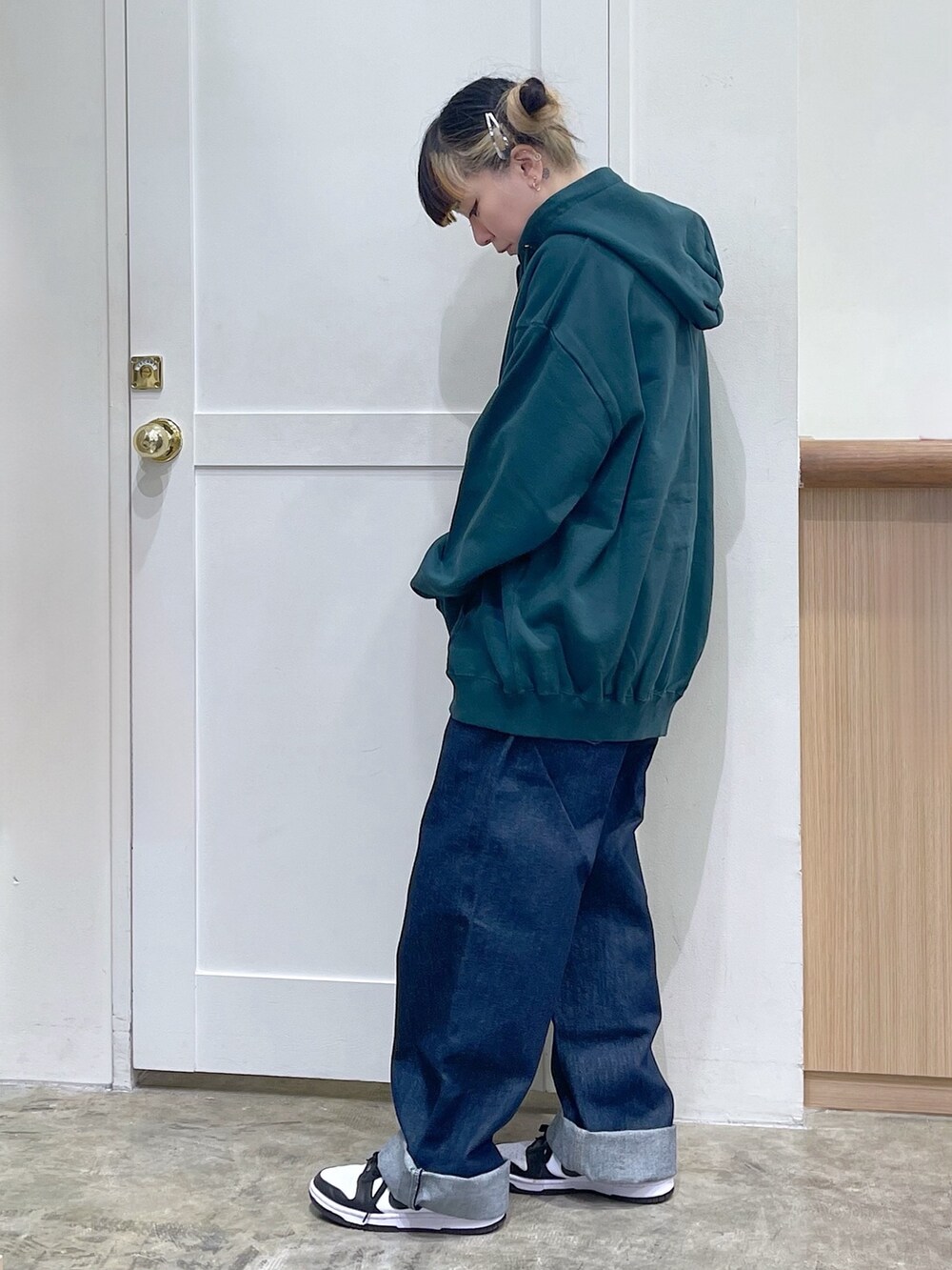 グリーン系のパーカー、ブルー系のサロペット/オーバーオール、ブラウン系のTシャツ/カットソーを着用したレディースの冬コーディネートの3枚目の写真