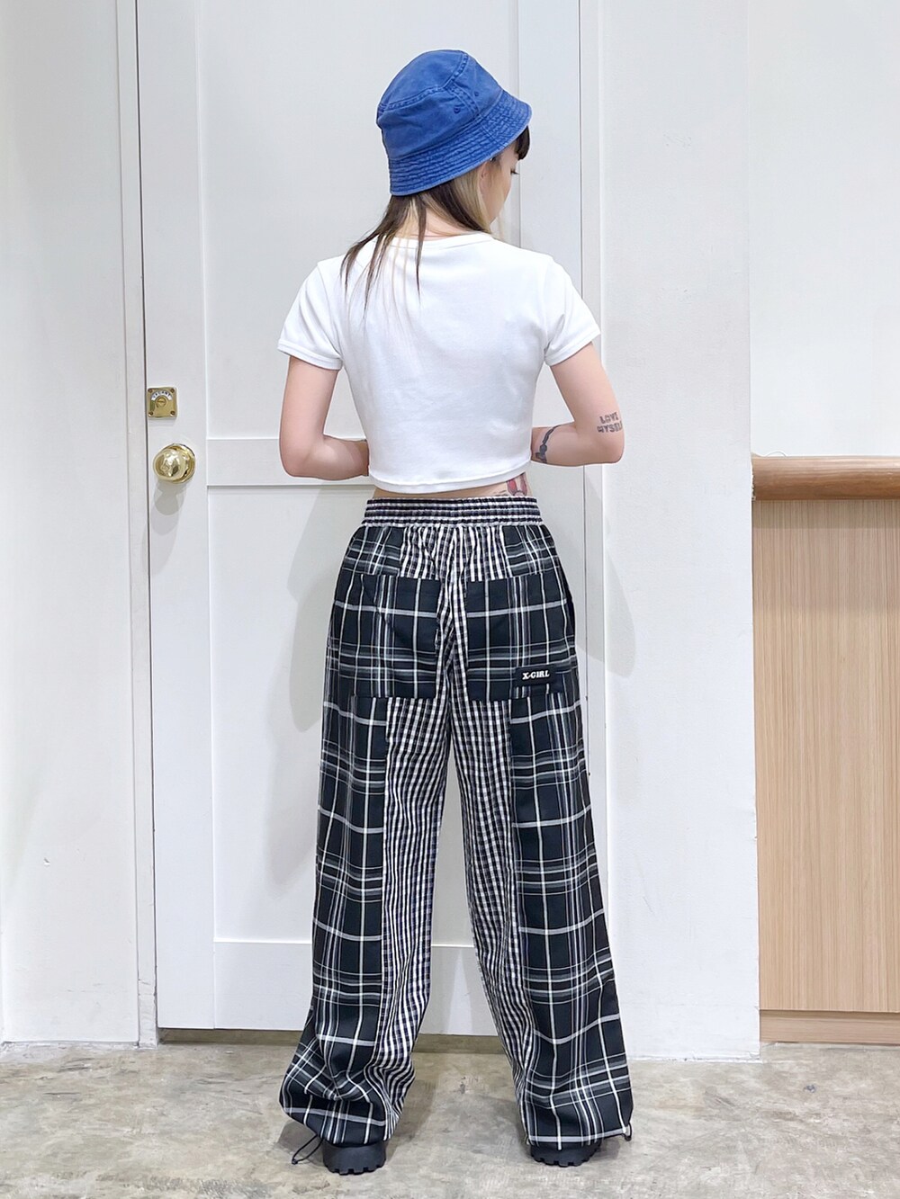 ブラック系のその他パンツ、ホワイト系のTシャツ/カットソー、ブルー系のハットを着用したレディースの夏コーディネートの4枚目の写真