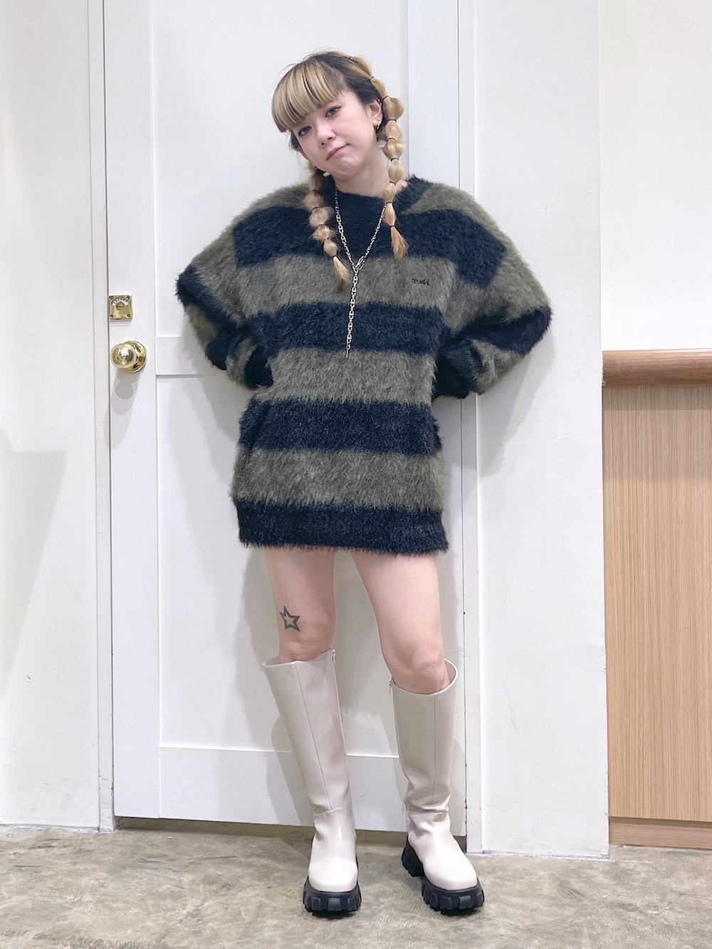 ブルー系のデニムジャケット、ブラック系のニット/セーター、ホワイト系のブーツを着用したレディースの冬コーディネートの4枚目の写真